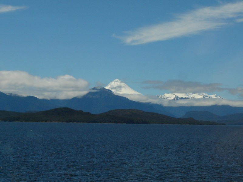 P1080817.JPG - Day 2: 1 pm: Volcan Cay (Conical shape) and Volcan Maca (obscured by clouds)