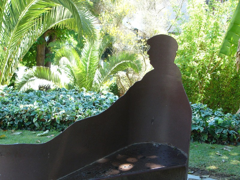 P1090379.JPG - Wrought iron garden seat with a silhouette of Pablo Neruda on the grounds of his home, La  Sebastiana